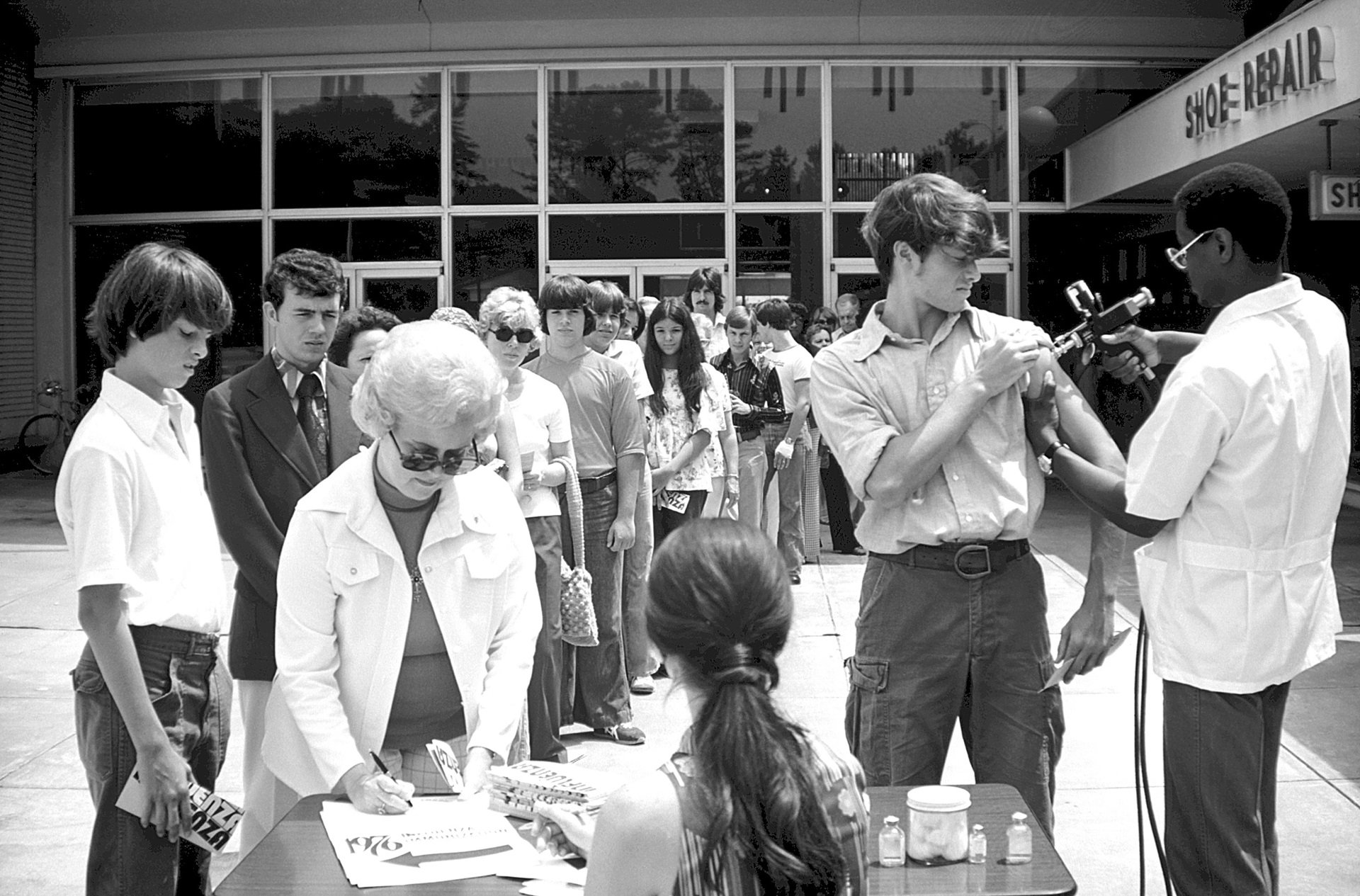 A line of people awaiting Influenza vaccination.
